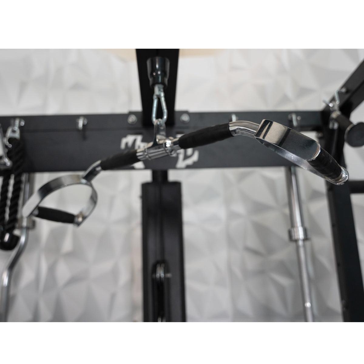 Close-up of a lat pulldown bar attached to a black fitness machine, with a white textured wall in the background.