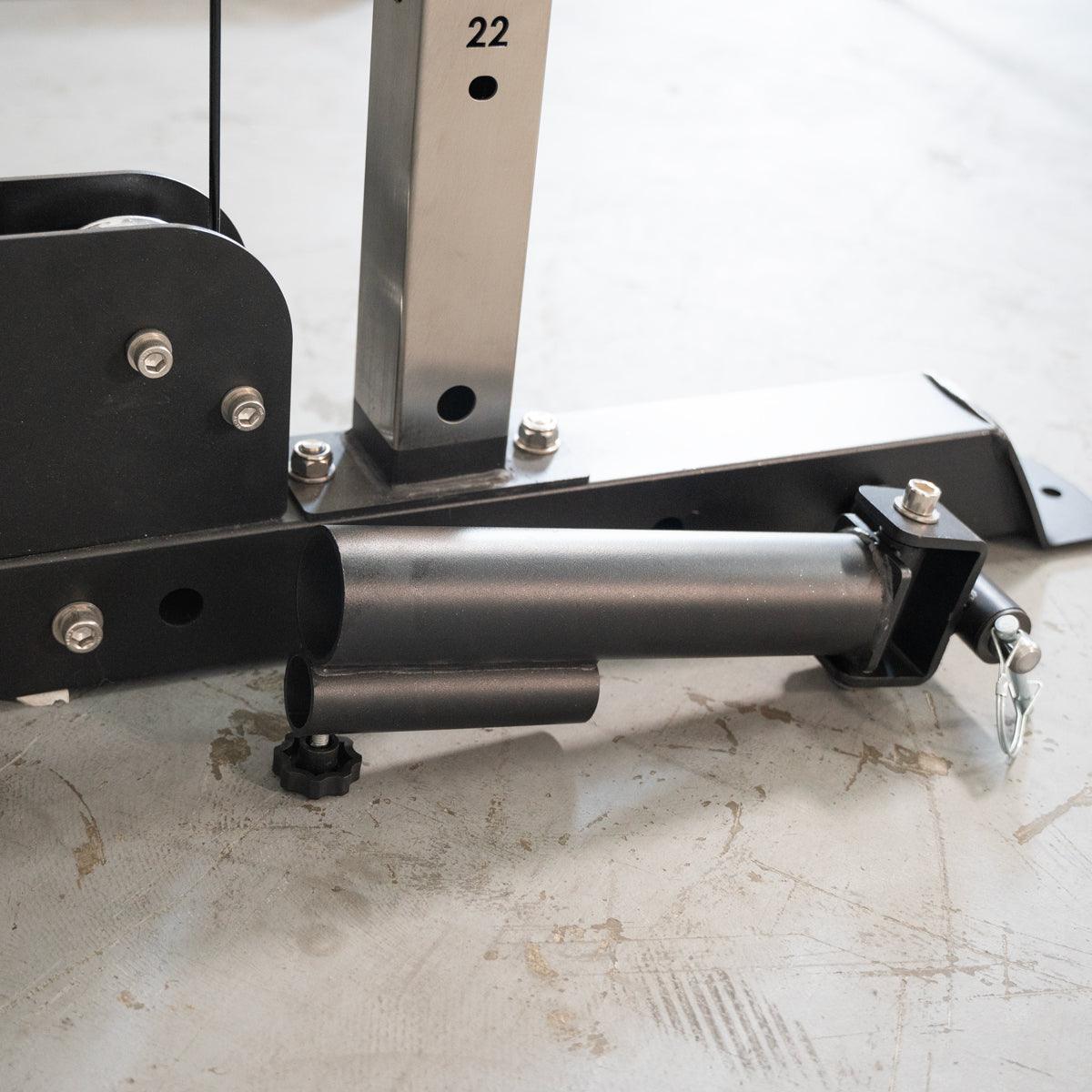 Close-up of the black metal base of a fitness machine with a silver vertical post marked "22".