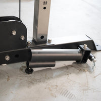 Thumbnail for Close-up of the black metal base of a fitness machine with a silver vertical post marked 