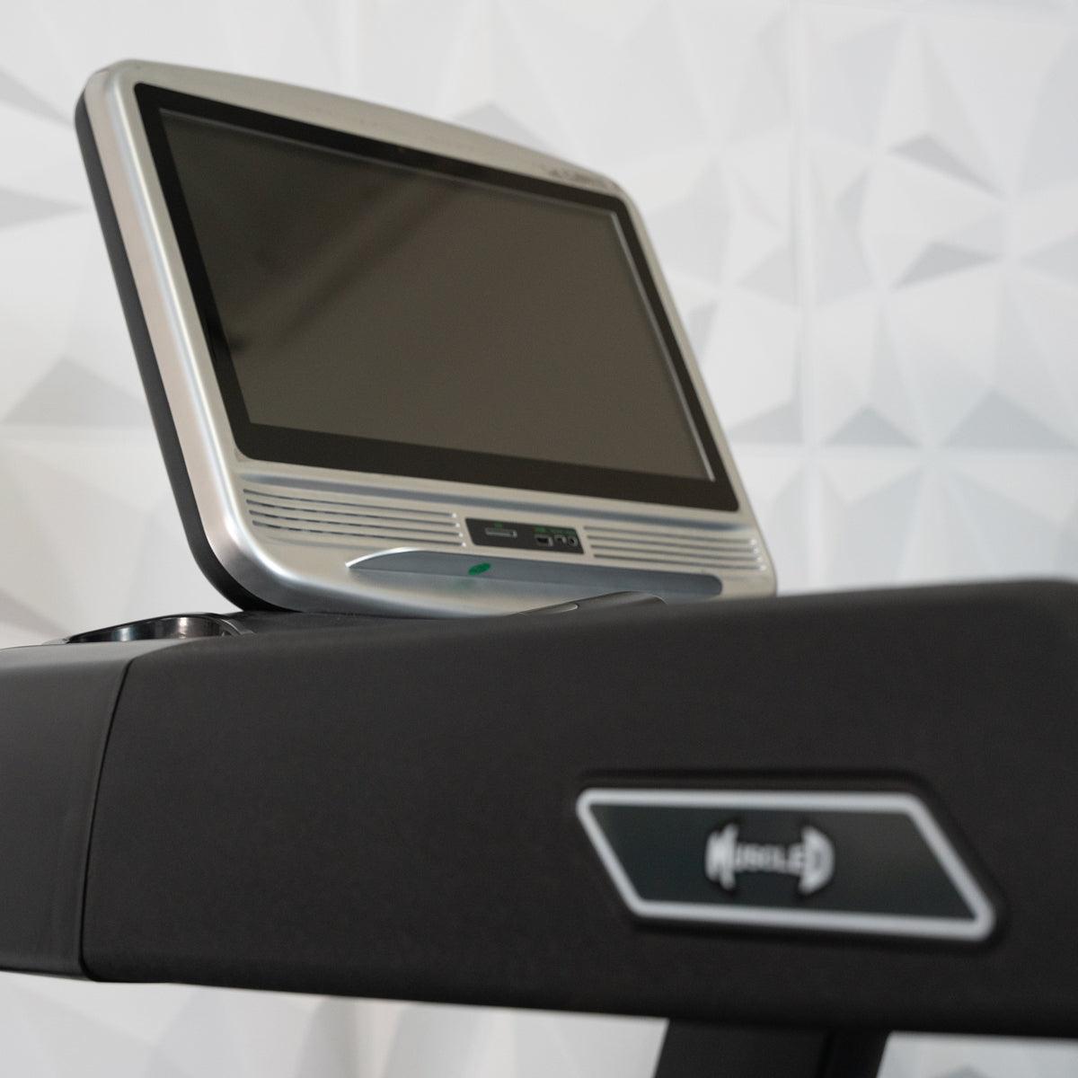 Close-up of a treadmill console with a silver-framed touch screen and a "Muscle D" logo.