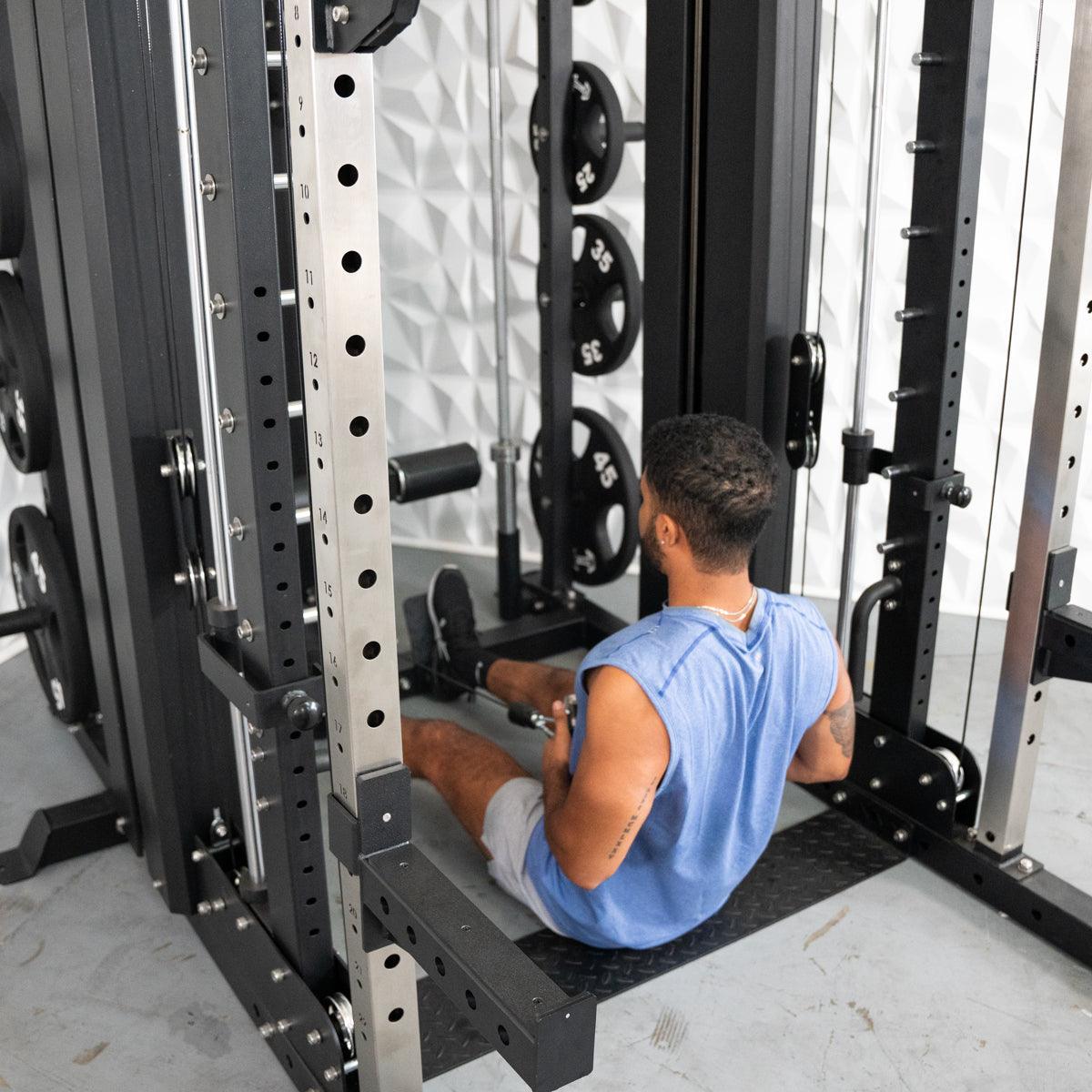 Man in blue shirt using a seated cable row machine with weights in a gym.