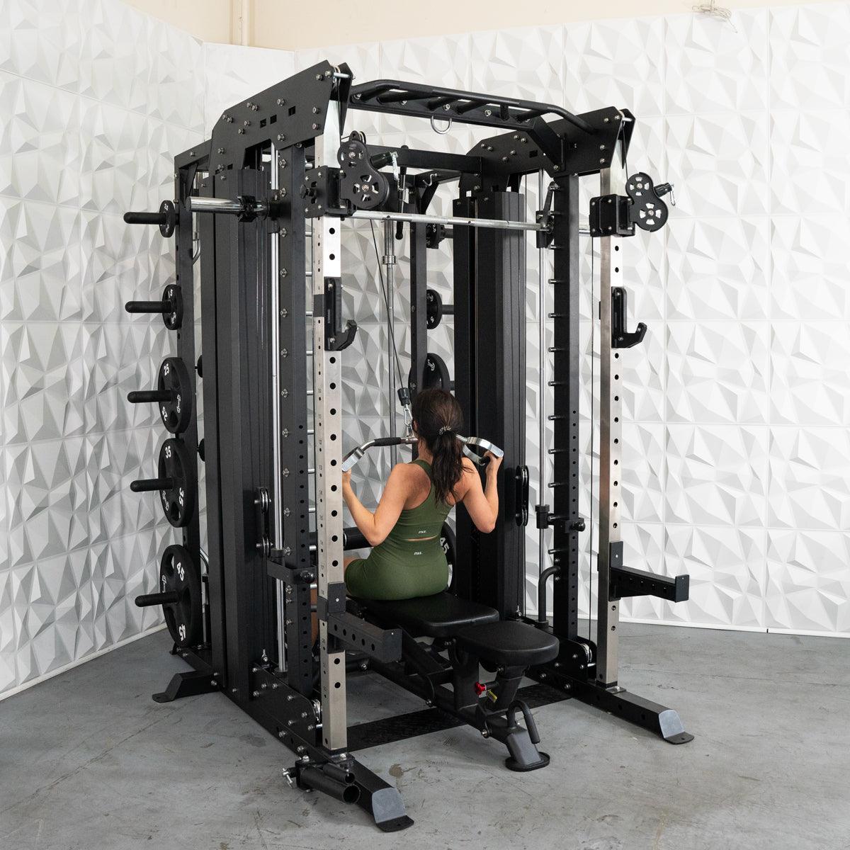 Woman doing lat pulldowns on a black multi-station home gym with weight plates.