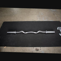 Thumbnail for Silver hard chrome curl bar with ergonomic angles, lying on a black mat.
