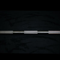 Thumbnail for Close-up of a stainless steel Olympic bar with knurled grip sections on a dark background.