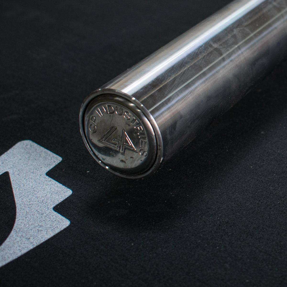 Close-up of a stainless steel Olympic bar end cap with "GP Industries" and a logo.
