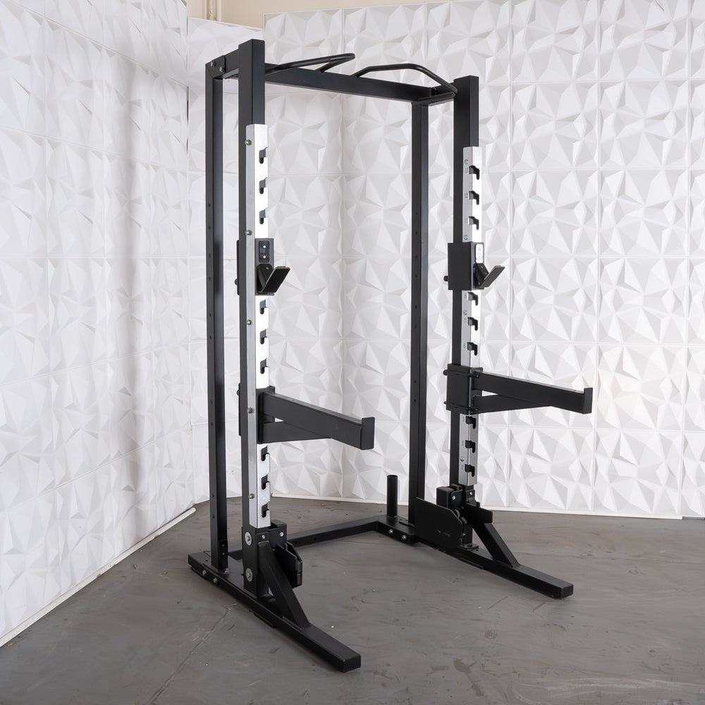Black and silver half rack with adjustable safety bars, pull-up bar, and vertical Olympic bar storage.