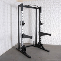 Thumbnail for Black and silver half rack with adjustable safety bars, pull-up bar, and vertical Olympic bar storage.
