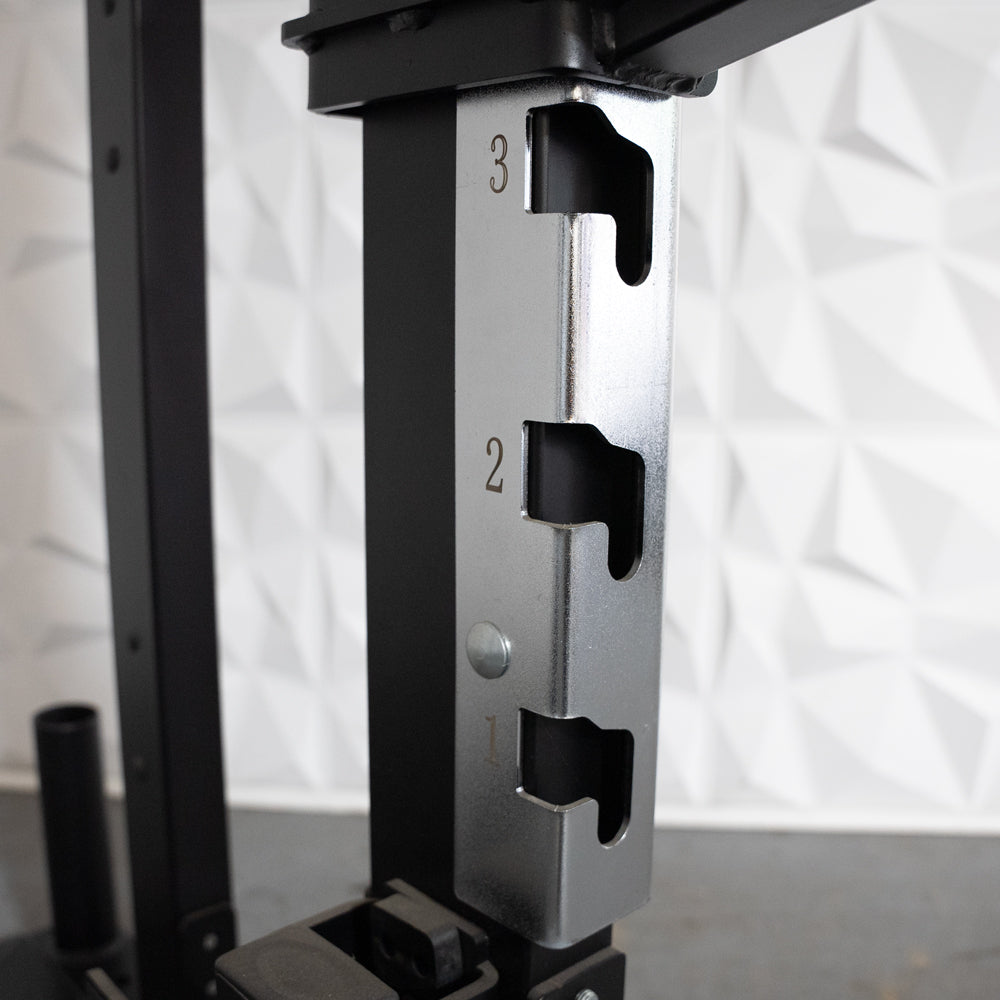 Close-up of a half rack's chrome-plated J-cup with numbered adjustment slots.