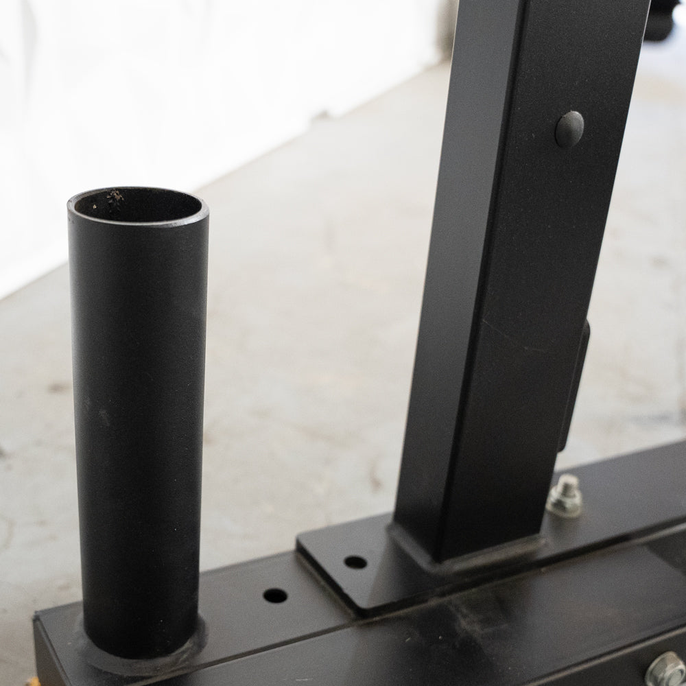 Close-up of the black vertical Olympic bar storage tube on the half rack base.