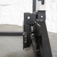 Thumbnail for Close-up of the black metal frame and adjustable components of a half rack on a concrete floor.
