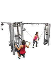 Thumbnail for Two women using a multi-station jungle gym with lat pull-down and cable crossover functions.