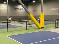 Thumbnail for Yellow padding on a steel column and angled I-beam between indoor pickleball courts