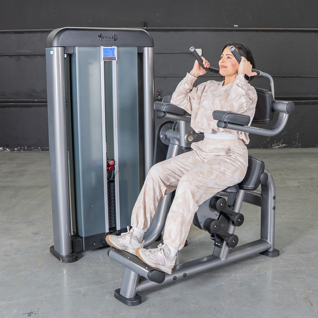 Woman using a grey Elite Plus AB Crunch machine with a pin selectorized weight stack.