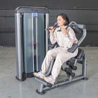 Thumbnail for Woman using a gray and black ab crunch machine with a weight stack.
