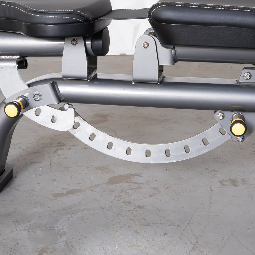Close-up of the adjustable mechanism on a gray exercise bench with black padded seats.