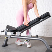 Thumbnail for Woman in pink adjusting a gray and black adjustable weight bench.