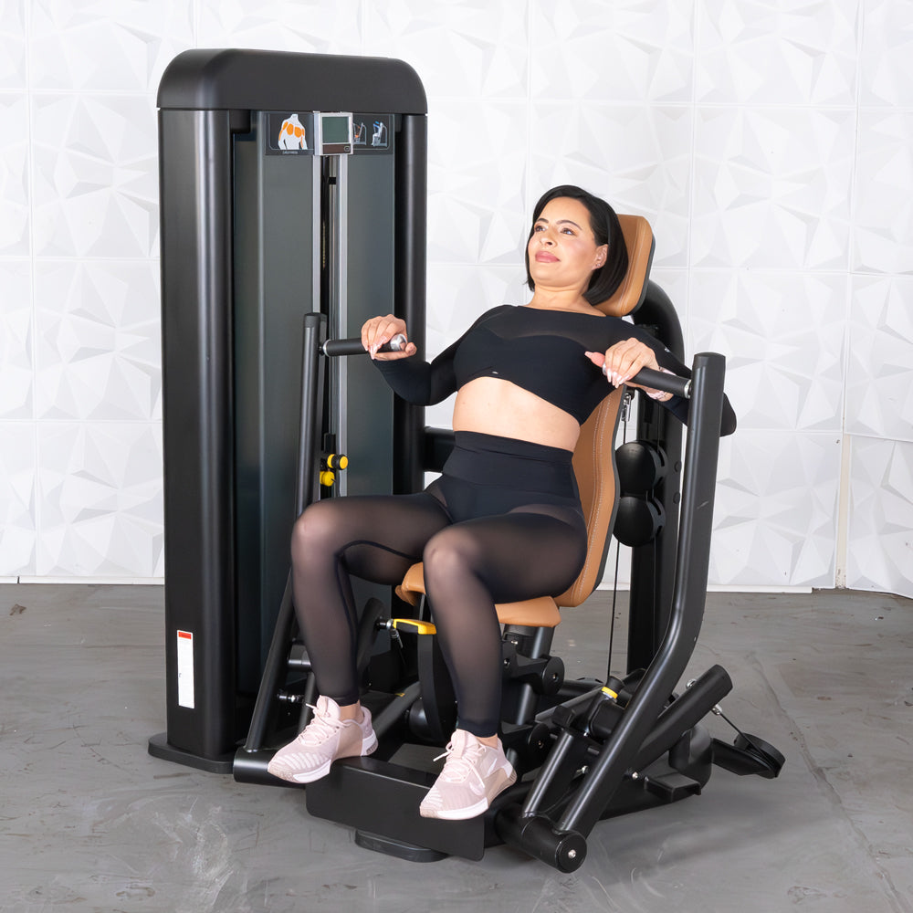 Woman in black activewear using a black and brown chest press machine.