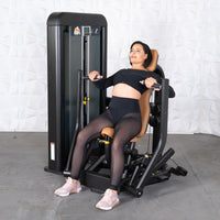 Thumbnail for Woman in black activewear using a chest press machine with tan upholstery.