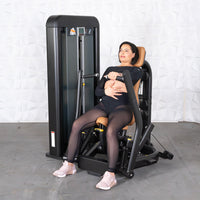 Thumbnail for Woman in black activewear sitting on a chest press machine with brown padding, hands on handles.