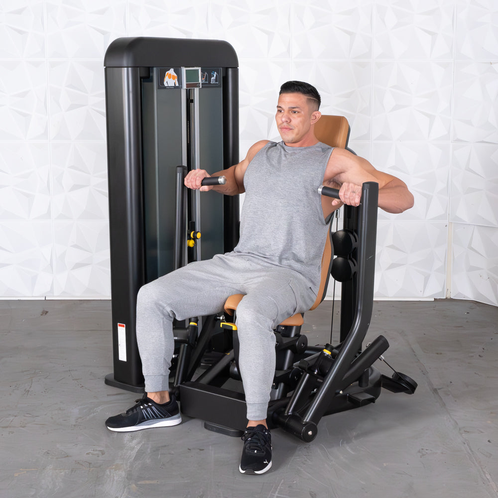 Man in gray tank top and sweatpants using a black and brown chest press machine.