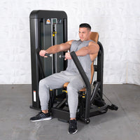 Thumbnail for Man in gray tank top and sweatpants using a black and brown chest press machine.