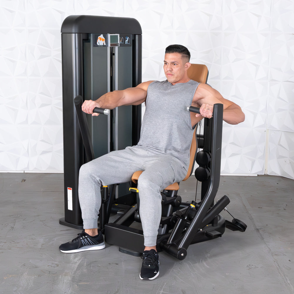 Man in gray tank top and sweatpants using a black and brown chest press machine.