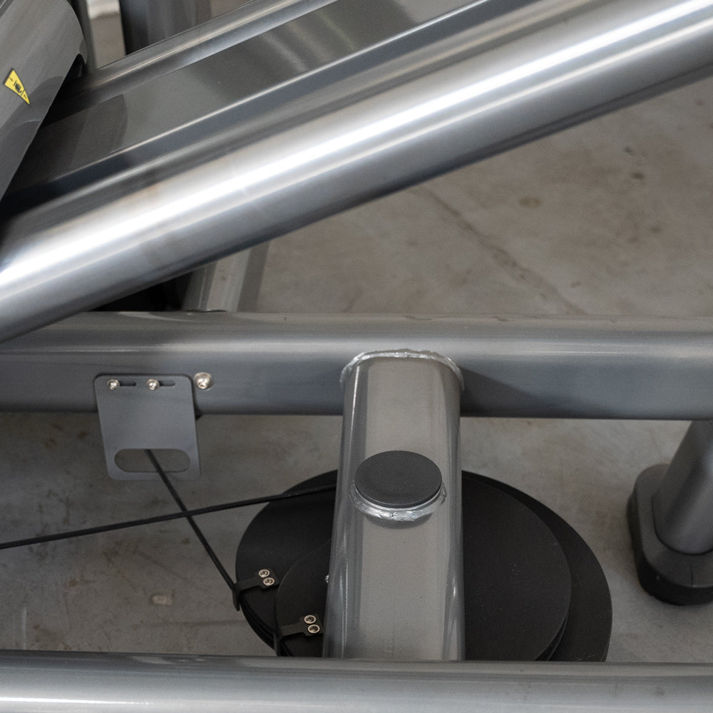 Close-up of the leg press machine's frame, showing metal tubing, a cable, and a pulley system.