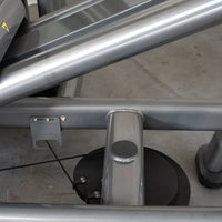 Thumbnail for Close-up of the leg press machine's frame, showing metal tubing, a cable, and a pulley system.