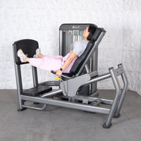 Thumbnail for Woman using a gray leg press and calf raise machine with a black seat and footplate.