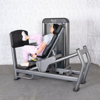 Thumbnail for Woman using a gray leg press machine with a black footplate and seat.