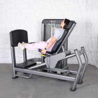 Thumbnail for Woman using a gray leg press and calf raise machine with a black footplate and seat.