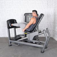 Thumbnail for Man using a gray leg press and calf raise machine with black pads in a gym.
