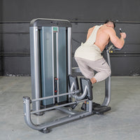 Thumbnail for Man using a gray glute blaster machine with foot platforms and handles in a gym.