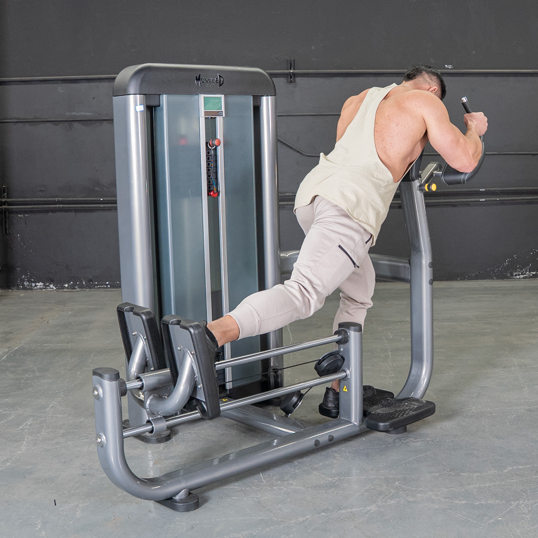 Man using a commercial glute blaster machine in a gym.