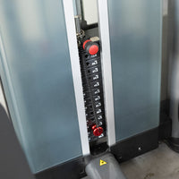 Thumbnail for Close-up of a weight stack with a red pin selector, showing weight plates labeled in kilograms.