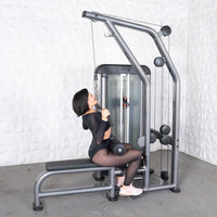Thumbnail for Woman performing a lat pulldown on a gray and black commercial fitness machine.