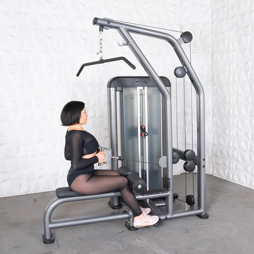 Woman using a gray lat pulldown and low row machine with a pin-selectorized weight stack.