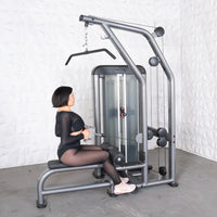 Thumbnail for Woman using a gray lat pulldown and low row machine with a pin-selectorized weight stack.