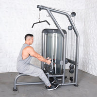Thumbnail for Man performing a low row exercise on a gray and black lat/low row machine with a pin-selectorized weight stack.
