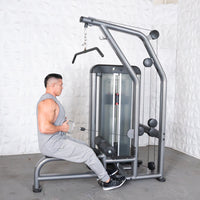 Thumbnail for Man in gray tank top and sweatpants using a gray lat/low row machine with a pin selectorized weight stack.