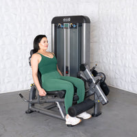 Thumbnail for Woman in green using a leg extension curl combo machine.