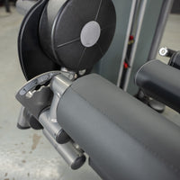 Thumbnail for Close-up of a leg extension curl machine's adjustable padded roller and numbered setting dial.