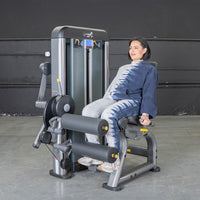 Thumbnail for Woman sitting on a leg extension curl combo machine, ready to exercise.