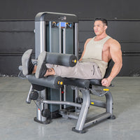 Thumbnail for Man using a gray leg extension curl combo machine in a gym.