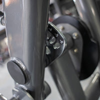 Thumbnail for Close-up of a leg extension machine showing the gray frame and a numbered adjustment dial.