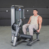 Thumbnail for Man seated on a gray leg extension machine in a gym.