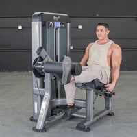 Thumbnail for Man using a grey and black leg extension machine in a gym.