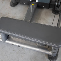 Thumbnail for Close-up of a gray padded seat with white stitching on a silver metal frame of a fitness machine.