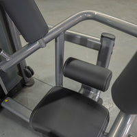 Thumbnail for Close-up of a rotary torso machine with black padded seat and backrest, and gray metal frame.