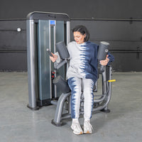 Thumbnail for Woman in tie-dye using a gray rotary torso machine for obliques workout.